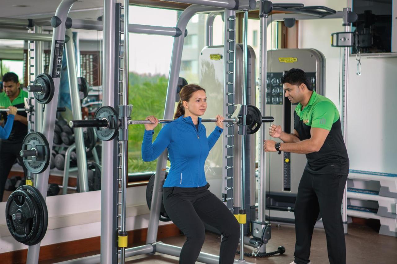 Jumeirah Messilah Beach Kuwait Кувейт Екстериор снимка A personal trainer assisting a woman with a squat